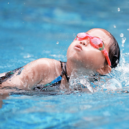 f a young swimmer wearing red goggles